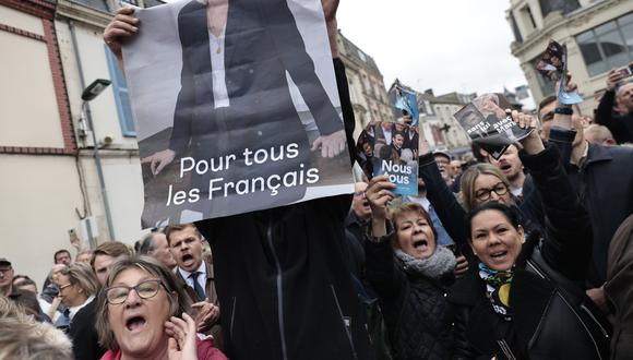 Personas apoyan a Macron y a Le Pen, quienes pelean por ganar las elecciones presidenciales francesas. AP