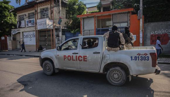 Policías armados viajan en la parte trasera de un camión después de que las calles de la capital de Haití, Puerto Príncipe, quedaran desiertas luego de un llamado a una huelga general el 18 de octubre del 2021. (RICHARD PIERRIN / AFP).