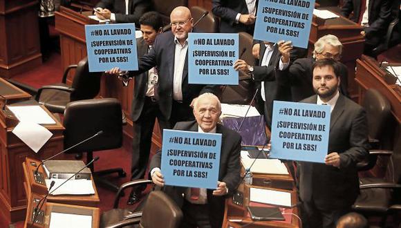 La mañana de ayer, varios congresistas portaron pancartas con las que buscaban que se debatiera la supervisión de cooperativas. (Foto: Hugo Pérez/ El Comercio)