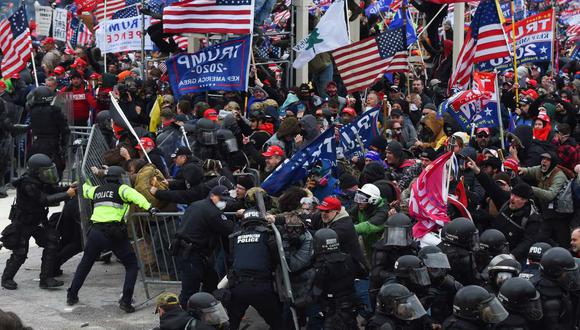 Los partidarios de Trump chocan con la policía y las fuerzas de seguridad mientras empujan barricadas para asaltar el Capitolio de los Estados Unidos, en Washington, el 6 de enero de 2021. (ROBERTO SCHMIDT / AFP).
