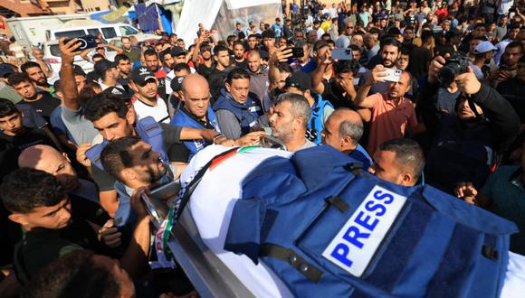 Periodistas, familiares y amigos rezan ante el cuerpo del periodista de la televisión palestina Mohamed Abu Hatab y 11 miembros de su familia el día después de su muerte en Gaza (MAHMUD HAMS / AFP).