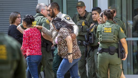 Custodiadas por la policía, las personas huyen del Robb Elementary School. AP