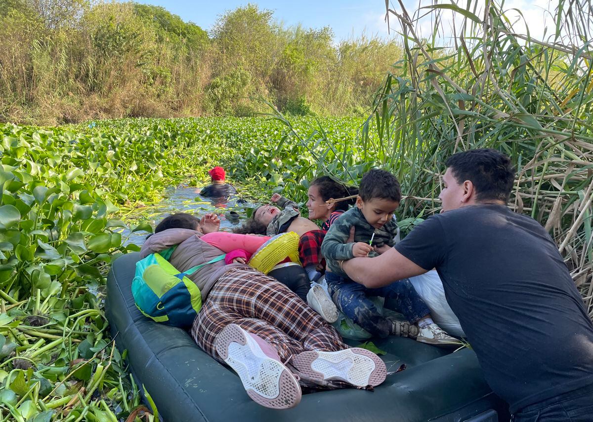 A group of migrants crosses the Rio Grande on an inflatable mattress on December 21, 2022, in the city of Matamoros, Tamaulipas, Mexico.  (Photo by Abraham Pineda Jácome / EFE)