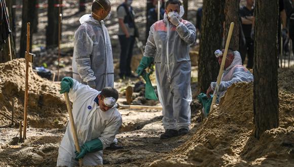 Técnicos forenses excavan en el sitio de una fosa común en un bosque en las afueras de Izyum, en el este de Ucrania, el 18 de septiembre de 2022. (Foto: Juan BARRETO / AFP)
