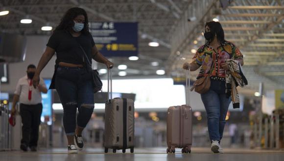 (ARCHIVOS) En esta foto de archivo tomada el 13 de abril de 2021, personas caminan en el área de embarque en el aeropuerto internacional de Galeao en Río de Janeiro, Brasil, el 13 de abril de 2021, en medio de la pandemia del coronavirus COVID-19. - La agencia nacional de salud de Brasil recomendó el 26 de noviembre de 2021 que el gobierno prohibiera a los viajeros que lleguen de seis países del sur de África una nueva variante de Covid-19 detectada en la región. (Foto de MAURO PIMENTEL / AFP)