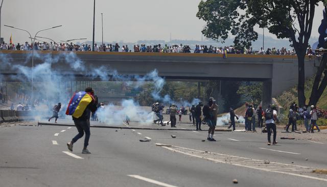 La Guardia Nacional arrojó gases lacrimógenos contra cientos de personas que intentaban bloquear una autopista en proximidades de la base aérea La Carlota, donde un grupo de militares se sublevó contra Nicolás Maduro. (EFE).