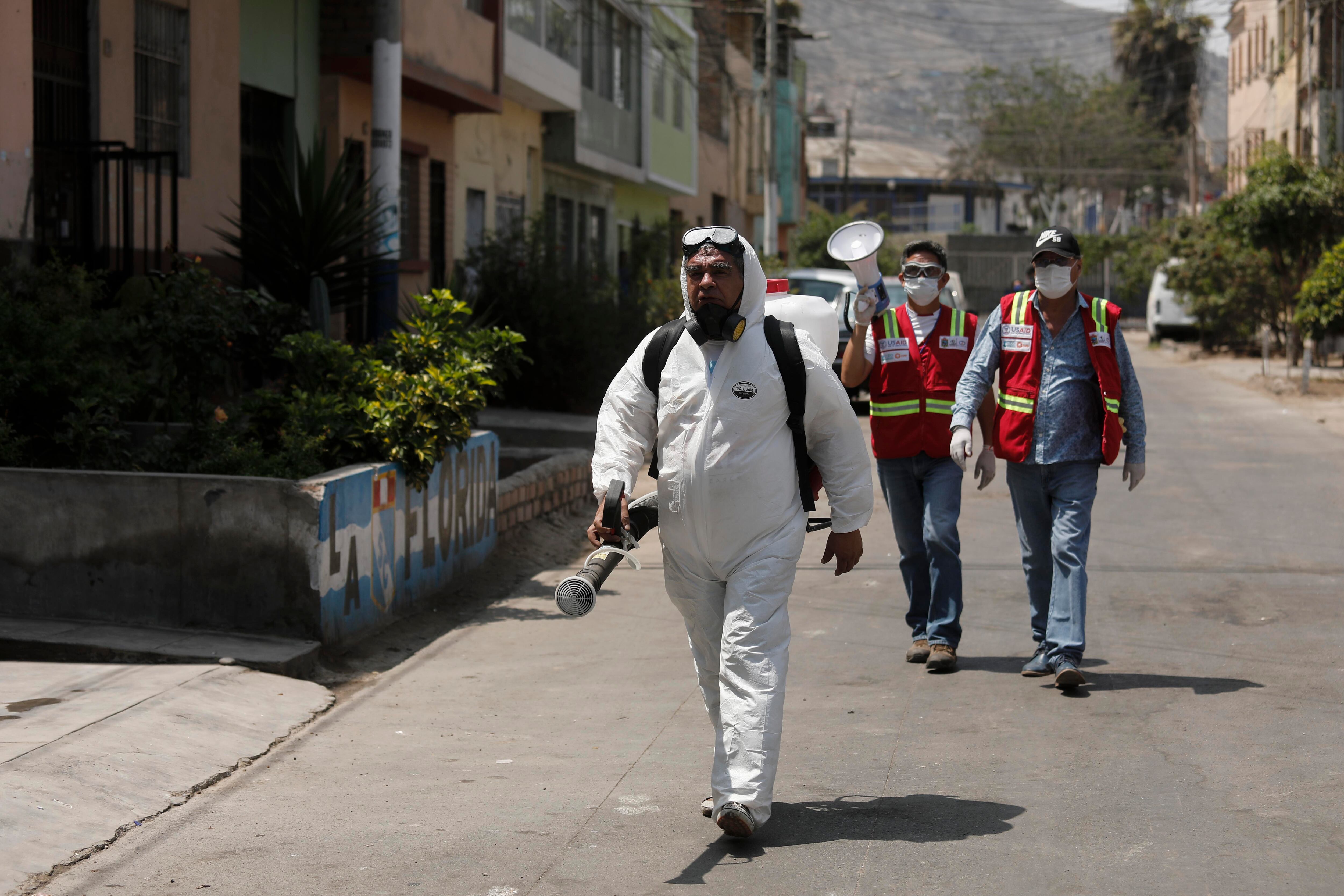 Personal de limpieza de la Municipalidad del Rímac continúa sus labores contra la propagación del COVID-19 en el distrito. El señor Antonio, cubierto de pies a cabeza, tiene la misión de rociar las fachadas y veredas con hipoclorito, una solución de agua y lejía capaz de matar al virus (Foto: Leandro Britto/GEC).