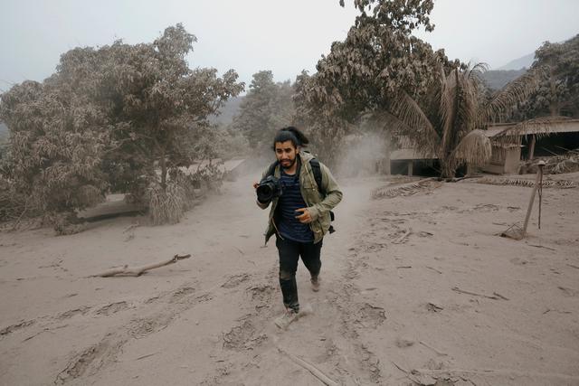 Un fotógrafo escapa en el momento de una nueva erupción del Volcán de Fuego. (Reuters).