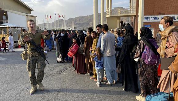 El pueblo afgano hace cola para abordar un avión militar estadounidense para salir de Afganistán, en el aeropuerto militar de Kabul después de la toma militar de Afganistán por los talibanes. (Foto: Shakib RAHMANI / AFP).