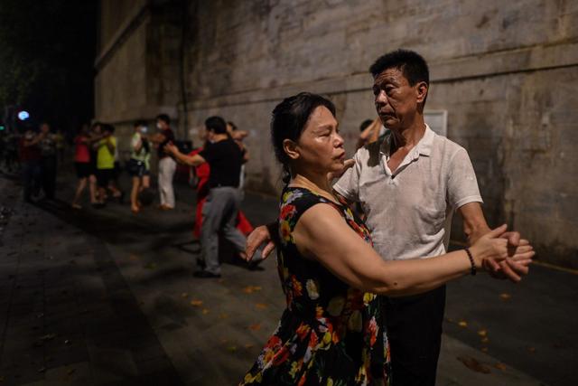Parejas bailan junto al río Yangtze en Wuhan, provincia de Hubei, China. Imagen del 5 de agosto de 2020. (AFP / Hector RETAMAL).