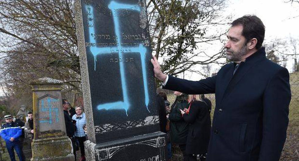 El ministro del Interior de Francia, Christophe Castaner, contempla una tumba vandalizada en el cementerio judío de Quatzenheim. (Foto: EFE)