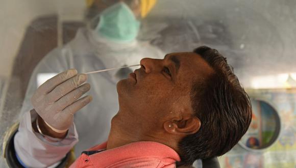 Un trabajador de la salud recolecta una muestra de un hisopo nasal de un hombre para analizar el coronavirus Covid-19 en Amritsar, India. (Foto de Narinder NANU / AFP).