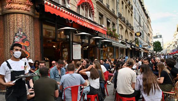 Un camarero que usa una mascarilla facial sirve a los clientes en la terraza del café restaurante "Le Bar du Marche", en París, el pasado 2 de junio, mientras los cafés y restaurantes reabren en Francia con la relajación de las medidas de confinamiento tomadas para frenar la propagación de COVID-19. (BERTRAND GUAY / AFP)
