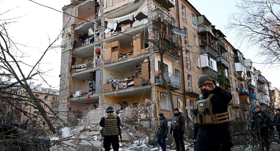 Policías ucranianos aseguran el área cerca de un edificio residencial de cinco pisos que fue bombardeado por Rusia en Kiev el 18 de marzo de 2022. (Serguéi SUPINSKY / AFP).