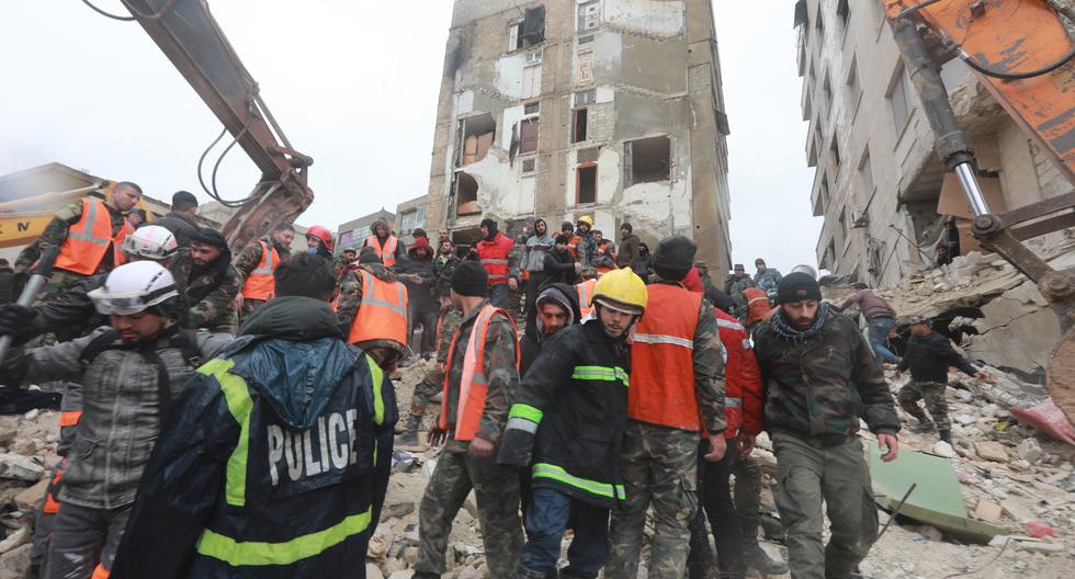 Miembros de la defensa civil de Siria y la policía buscan sobrevivientes bajo los escombros después de un terremoto en la ciudad de Hama, en el centro del país, el 6 de febrero de 2023. (Foto de LOUAI BESHARA / AFP).