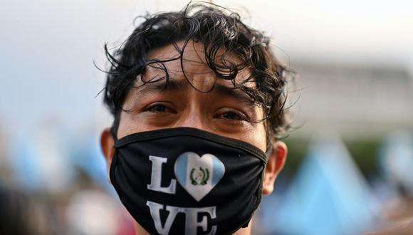 Un manifestante llora mientras participa en una protesta exigiendo la renuncia del presidente guatemalteco Alejandro Giammattei, en la Ciudad de Guatemala el 22 de noviembre de 2020. (Foto de Johan ORDONEZ / AFP).