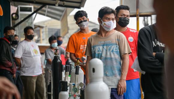 Los indonesios hacen cola en una tienda de almacenamiento de oxígeno para llenar los tanques de los familiares enfermos de coronavirus en Yakarta el 30 de junio de 202. (Foto de BAY ISMOYO / AFP).