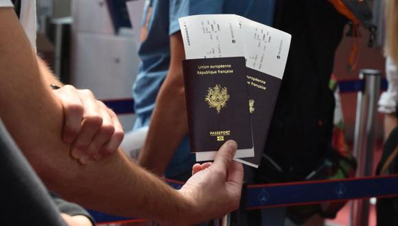 Los pasajeros portan sus pasaportes con documentos de viaje de Air France con documentación sanitaria 'listos para volar' en el aeropuerto Roissy Charles de Gaulle, al norte de París. (Foto: Eric PIERMONT / AFP).