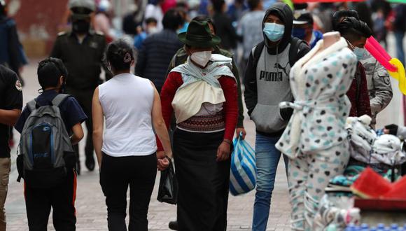 Varias personas caminan frente a comercios informales en las calles de Quito (Ecuador). (Foto: EFE/ José Jácome/Archivo).