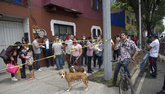Las personas y sus perros permanecen fuera de los edificios en la Ciudad de México tras el terremoto de magnitud 7,5 con epicentro en Oaxaca. (Foto por CLAUDIO CRUZ / AFP).