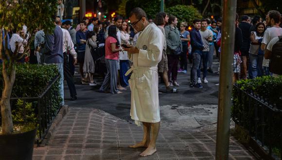 TOPSHOT - People gather on a street in downtown Mexico City during an earthquake on September 7, 2017.  A powerful 8.0 magnitude earthquake struck southern Mexico late September 7, the US Geological Survey said, with seismologists warning of a tsunami of more than three meters (10 feet). / AFP / Luis PEREZ