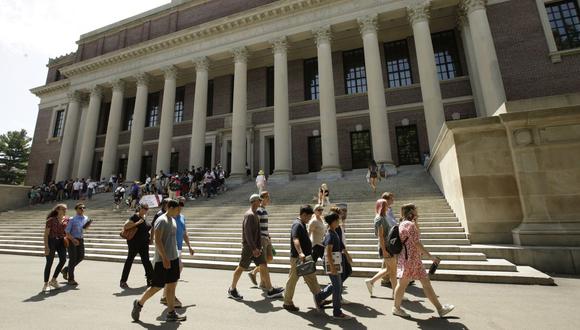 La gente pasa por una entrada a la Biblioteca Widener, detrás, en el campus de la Universidad de Harvard, en Cambridge, Massachusetts. (Foto: Archivo / AP / Steven Senne).