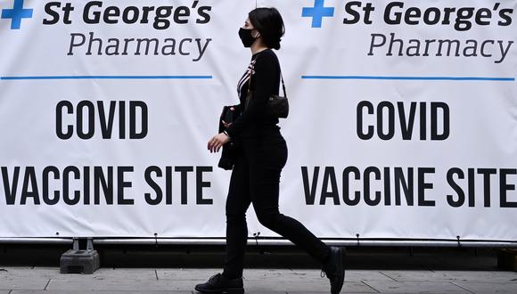 Una persona camina al frente de un centro de vacunación contra el coronavirus, en Londres. EFE