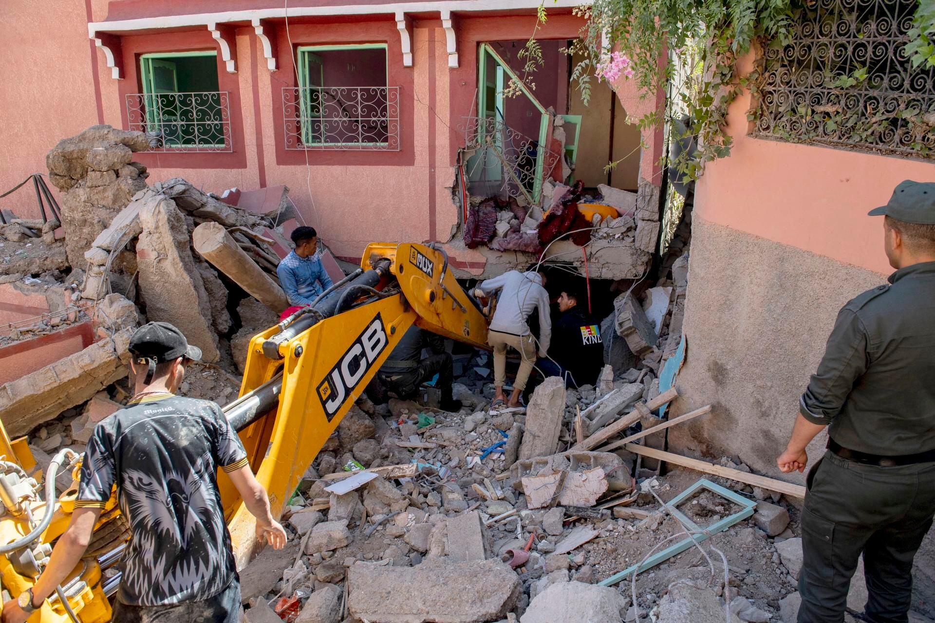 People search through the rubble of a damaged building with the help of an excavator after an earthquake in Marrakech, Morocco, on September 9, 2023. (EFE/EPA/JALAL MORCHIDI).