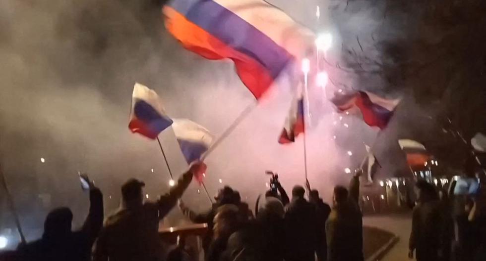 Una captura de video tomada el 22 de febrero de 2022 muestra a personas ondeando banderas de Rusia y celebrando en Donetsk, luego de la decisión del presidente ruso Vladimir Putin de reconocer su independencia. (AFP).