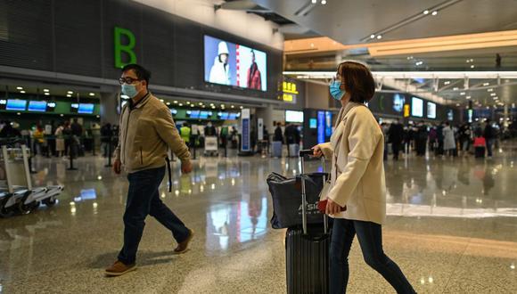 Los pasajeros que usan mascarillas como medida preventiva contra el coronavirus se ven en el Aeropuerto Internacional de Shanghái Hongqiao, el 27 de noviembre de 2020. (Héctor RETAMAL / AFP)