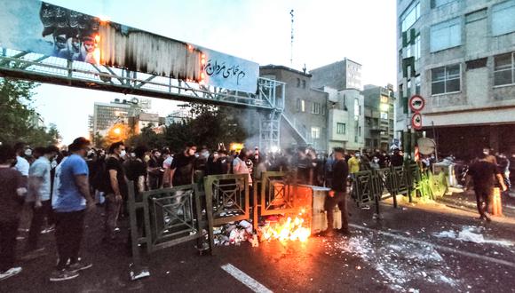 La imagen muestra a manifestantes iraníes quemando un contenedor de basura en la capital, Teherán, durante una protesta por Mahsa Amini, días después de que muriera bajo custodia policial. (Foto: AFP)