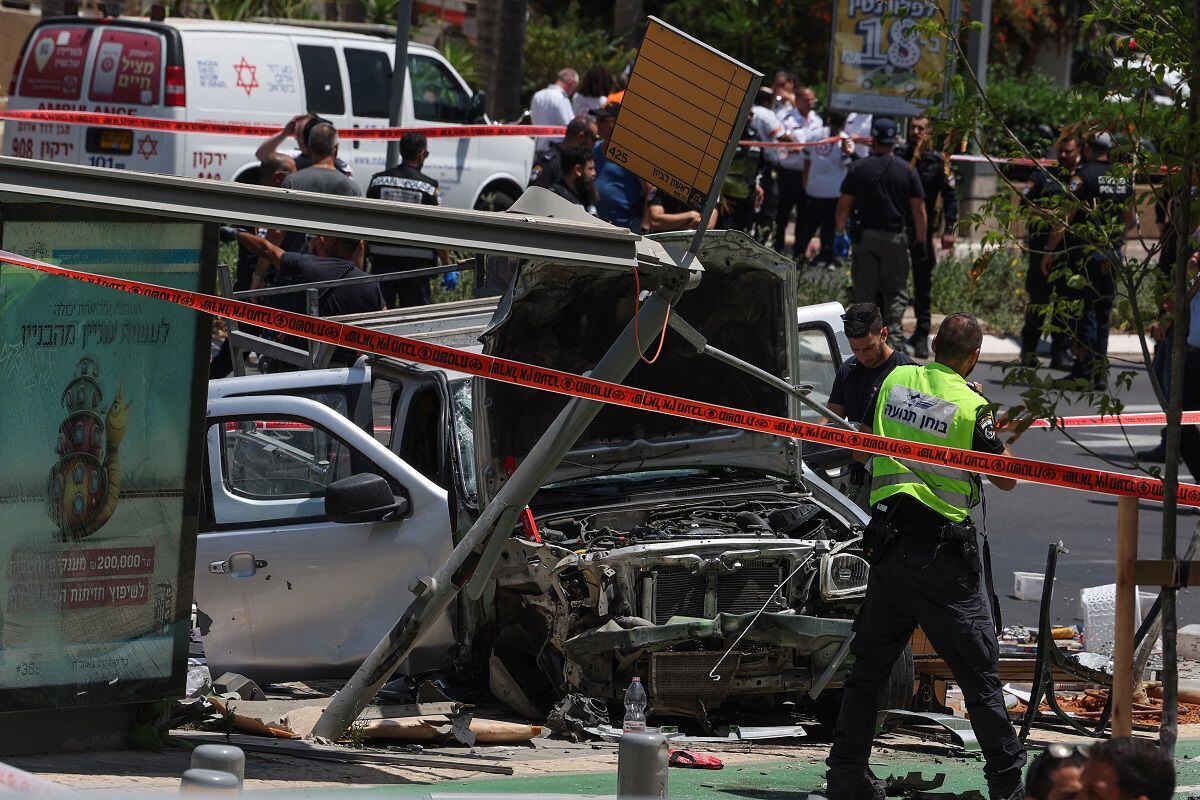 Israeli security and emergency personnel work at the site of a car ramming attack in Tel Aviv on July 4, 2023. (Photo by JACK GUEZ/AFP)