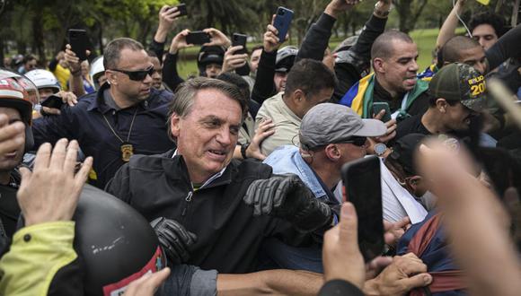 El presidente brasileño y candidato a la reelección, Jair Bolsonaro, saluda a sus seguidores durante una caravana en la víspera de las elecciones presidenciales, en Sao Paulo, Brasil. (Foto por ERNESTO BENAVIDES / AFP)