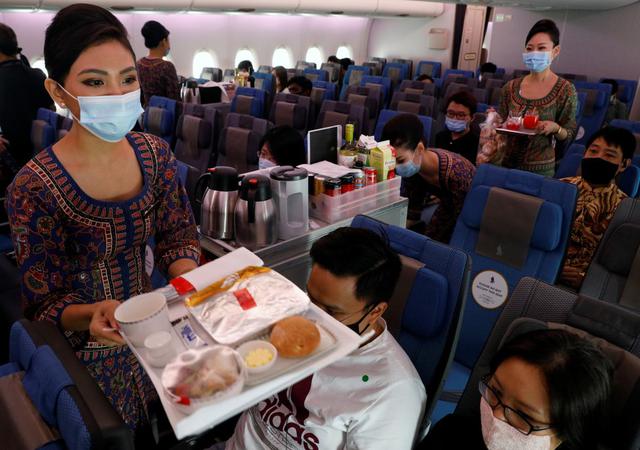 Las azafatas de Singapore Airlines sirven comida a bordo en la cabina de clase económica de su restaurante A380 en el aeropuerto de Changi en Singapur. Las autoridades de la compañía decidieron abrir el local tras verse afectados por la pandemia de coronavirus. (REUTERS/Edgar Su).