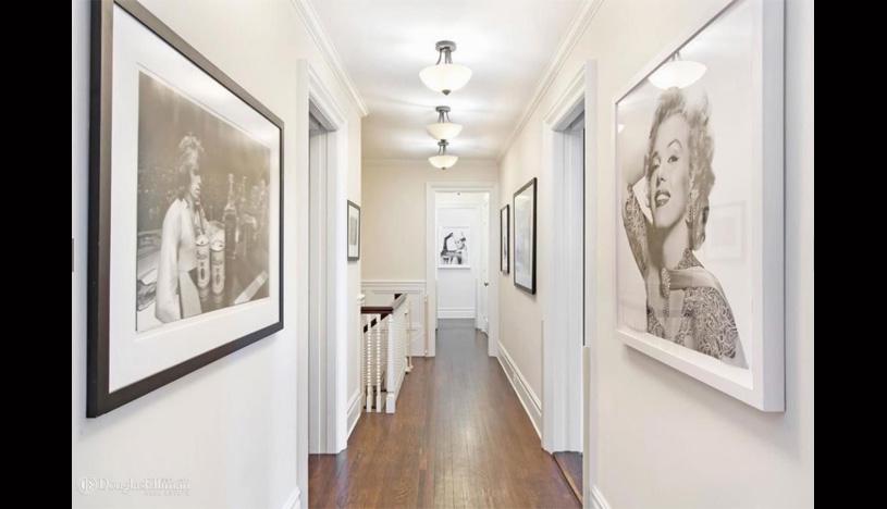 Los pasillos de la casa, que interconectan los ambientes, proyectan un estilo elegante. Llama la atención los cuadros en blanco y negro que hacer referencia a la cultura pop. (Foto: Trulia)