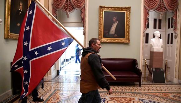 Un seguidor de Trump camina dentro del Congreso estadounidense con la bandera confederada, aquella que enarbolaban los esclavistas en la guerra civil. REUTERS/Mike Theiler