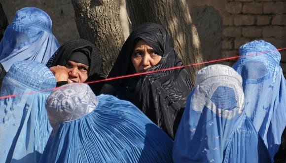 Imagen referencial | Las mujeres afganas esperan para recibir ayuda alimentaria de la gestión de desastres de Afganistán, en Herat el 2 de marzo de 2023. (Foto de Mohsen Karimi / AFP)