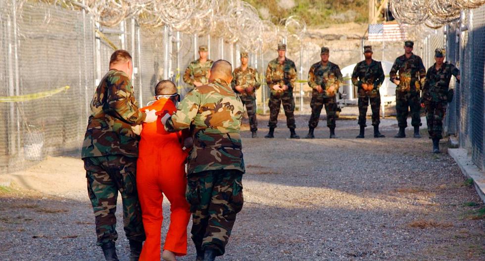 Esta fotografía tomada en enero del 2002 muestra a un detenido siendo transportado al Campo X-Ray dentro de la prisión de Guantánamo, el lugar era utilizado para las interrogaciones pero cerró a los pocos meses. Unos 779 prisioneros han pasado por Guantánamo en estos 19 años de funcionamiento, actualmente mantiene a 40 reos, la mayoría sin cargos en su contra. (Foto: Peter Muhly / Archivo AFP)