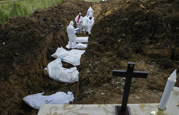 Un equipo forense entierra a un grupo de migrantes que murieron tratando de cruzar la peligrosa jungla del Darién, en el cementerio de Guayabillo en Agua Fría, Panamá, el jueves 30 de septiembre de 2021. (Foto AP/Arnulfo Franco).