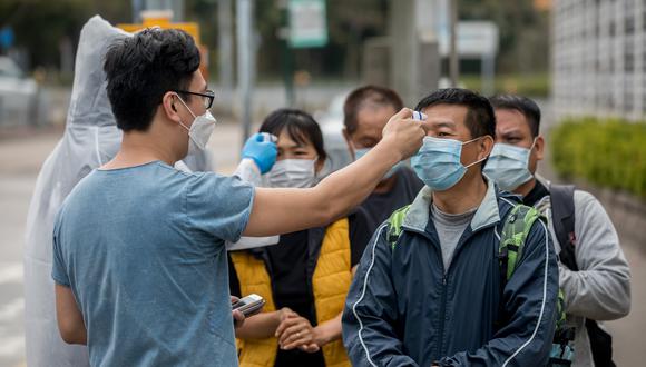 Imagen referencial en donde se ve cómo a un grupo de personas se les mide la temperatura en Shenzhen. Bloomberg