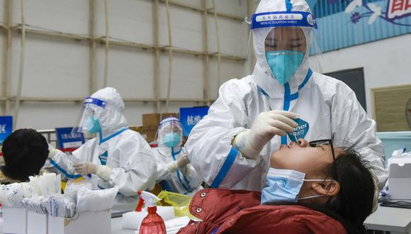 Esta foto tomada el 16 de enero de 2022 muestra a un residente que se somete a una prueba de ácido nucleico para detectar el coronavirus Covid-19 en Ningbo, en la provincia oriental china de Zhejiang. (Foto de AFP)