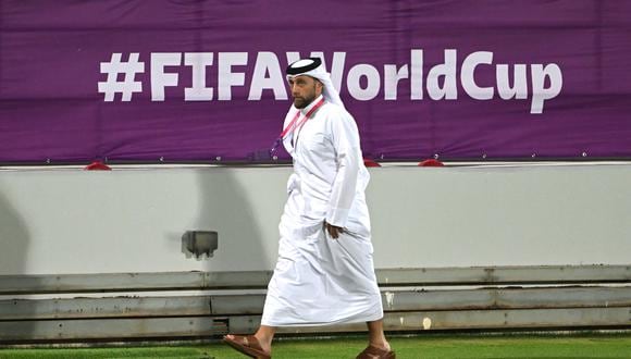 Un hombre pasa frente a un logotipo de la Copa Mundial de la FIFA durante la sesión de entrenamiento alemana en el estadio Al Shamal, el 20 de noviembre de 2022, antes del torneo de fútbol de la Copa Mundial de Qatar 2022. (Foto de INA FASSBENDER / AFP)