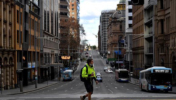 Esta imagen tomada el 26 de junio de 2021 muestra a un hombre caminando por las tranquilas calles de Sídney durante un nuevo confinamiento por coronavirus. (Saeed KHAN / AFP).