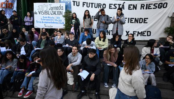 Estudiantes de Medicina de la Universidad de Buenos Aires (UBA) hacen una conferencia abierta en la entrada de la universidad para protestar contra las recientes medidas económicas del presidente Javier Milei. (Foto de LUIS ROBAYO / AFP).