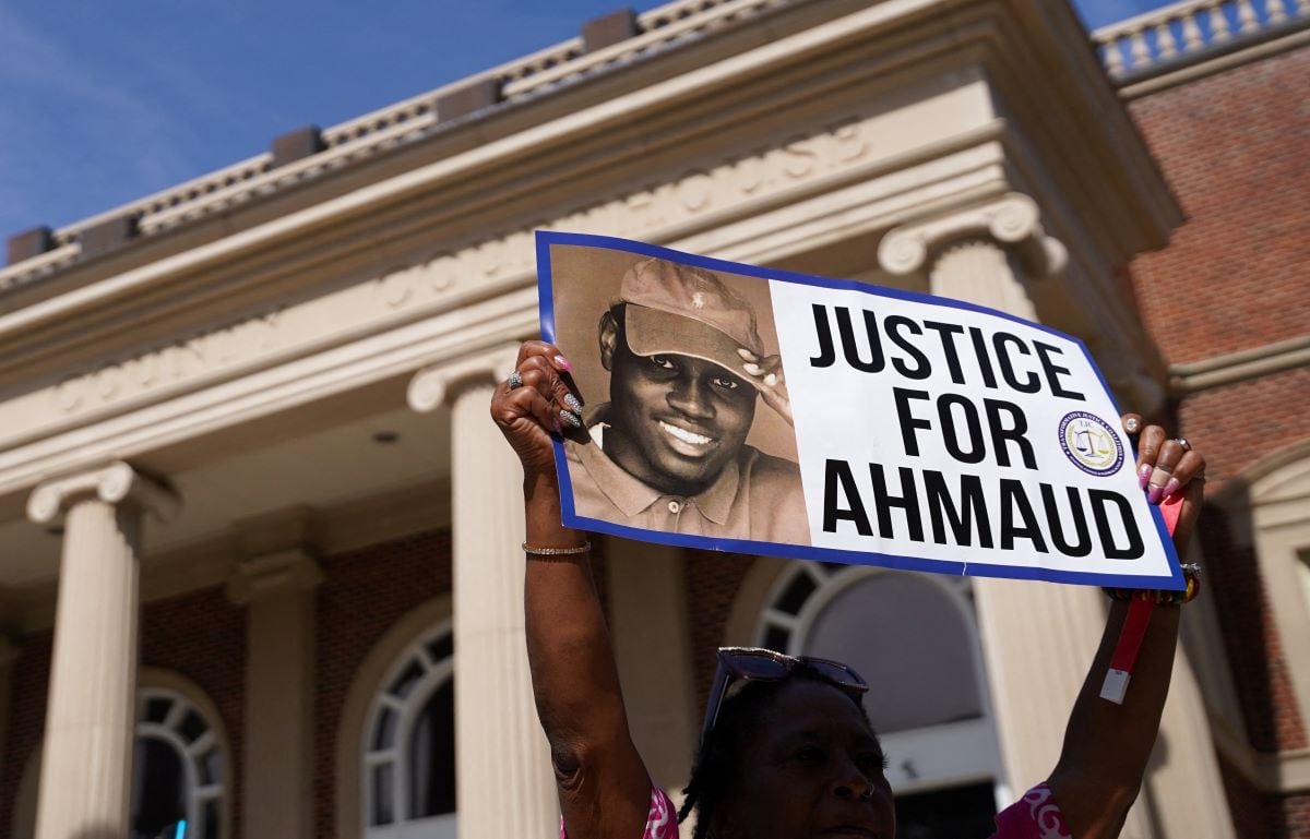 In this file photo taken on January 18, 2021, a protester holds up a placard at the Glynn County Courthouse.  (SEAN RAYFORD / GETTY IMAGES NORTH AMERICA / AFP).