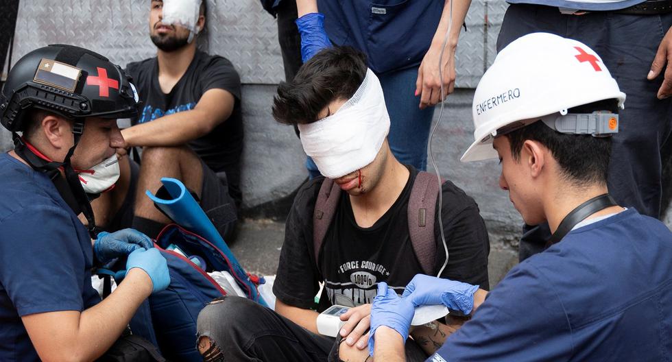 El estudiante Gustavo Gatica recibe los primeros auxilios luego de que la policía de Chile le disparara perdigones en la cara durante una protesta. (Reuters).