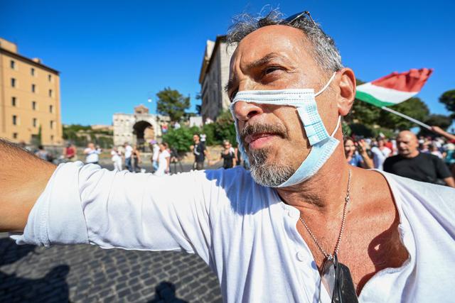 Un hombre con una mascarilla recortada participa en una protesta de los movimientos "No Mask", negacionistas del Covid-19, movimientos anti-5G y movimientos anti-vacunación. (AFP / Vincenzo PINTO).