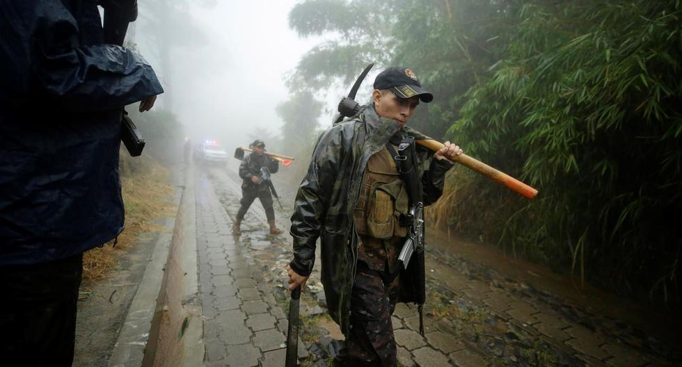 Militares salen de la zona donde fallecieron soterrados cinco soldados, mientras se resguardaban de la lluvia en Comasagua, El Salvador. (EFE/Rodrigo Sura).