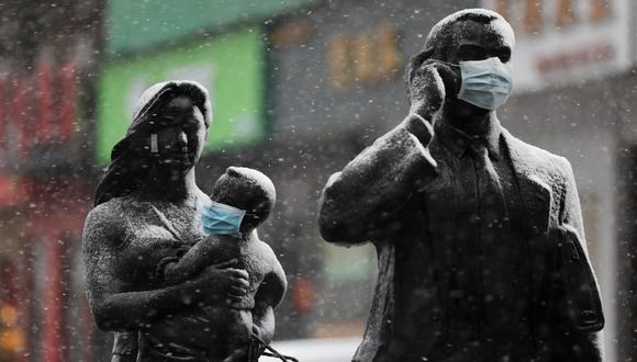 Estatuas con mascarillas faciales en medio de la nieve en Wuhan, el epicentro del nuevo brote de coronavirus. (Reuters).