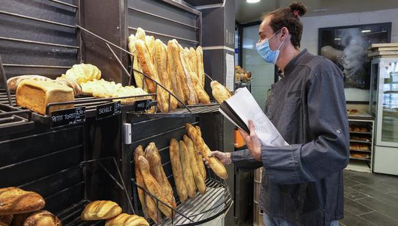 El panadero Hugo Hardy prepara baguettes en la panadería Bigot en Versalles, oeste de París, el martes 26 de octubre de 2021. (AP Foto/Michel Euler).